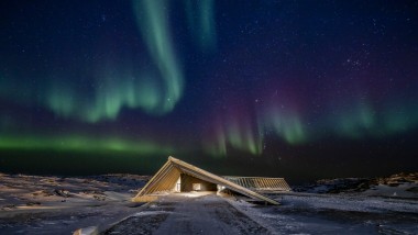 The Icefjord Centre in the spectacular northern lights of the Greenlandic polar night (© Adam Mørk)